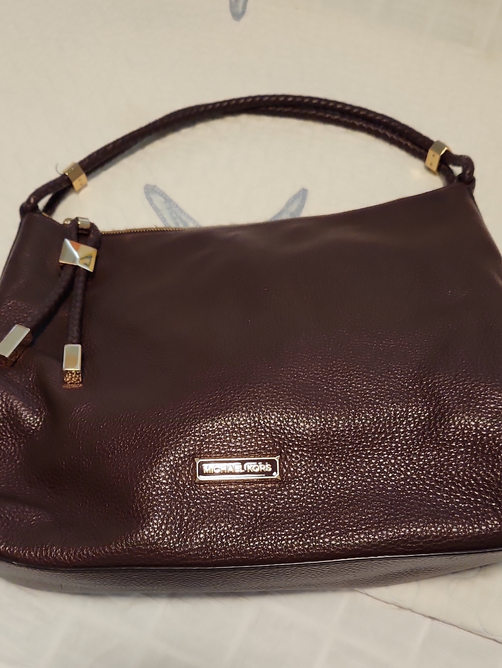 Soft Leather, More like a dark burgundy/wine Color. Beautiful bag,used 2-3 times